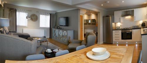 a kitchen and living room with a table and a couch at Five Star Stays in Scarborough
