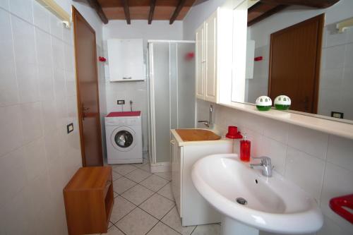 a bathroom with a sink and a washing machine at Guest House Formigine in Formigine