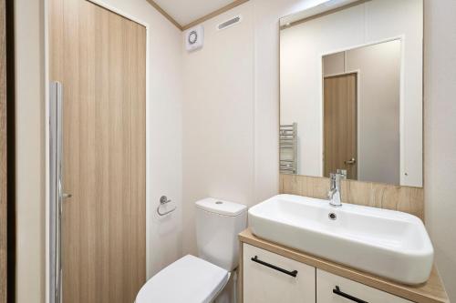 ヨークにあるFir Tree Lodge with Hot Tubの洗面台、トイレ、鏡のあるバスルーム