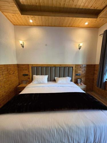 ein Schlafzimmer mit einem großen Bett mit weißer Bettwäsche in der Unterkunft Khili's Abode in Harsil