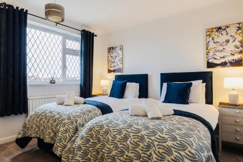 two beds in a bedroom with blue and white at Danby House Messingham nr M181 Motorway - Humberside Airport, Elsham, Lincoln - We welcome Family & Contractor Stays in Messingham
