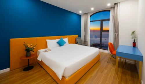a bedroom with a large bed and a blue wall at Atermis Regency Hillside Phu Quoc - Sea & Fireworks view- Gym & Pool Access in Phu Quoc