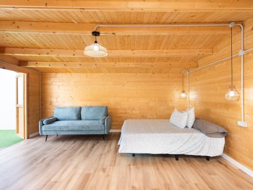 a bedroom with a bed and a blue couch at Live Villa Adrian in Caleta de Interián