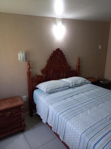 バイア・ダ・トライカオにあるPousada Catumbaéの木製のヘッドボードが付いた大きなベッドのある寝室