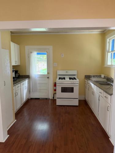 a kitchen with white cabinets and a stove at Blue Moon Guest House in Lafayette