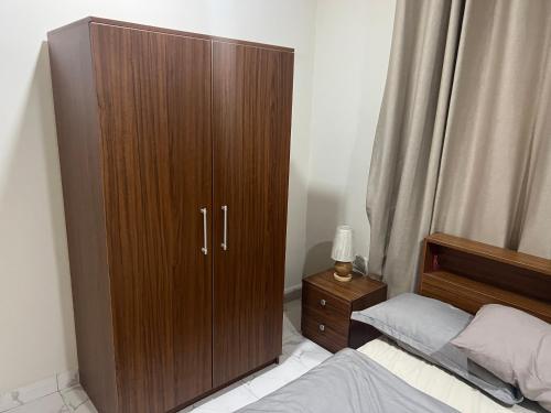 Un gran armario de madera en un dormitorio con una cama. en DSK Residence, en Accra