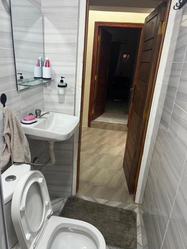Un baño con un inodoro blanco y un lavabo. en DSK Residence, en Accra