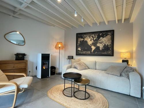 een woonkamer met een bank en een tafel bij Le Gîte du Pèlerin avec piscine in Florennes