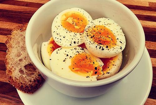 Un bol de huevos en un plato con un trozo de pan en IHOC - Phuket OldTown, en Ban Lo Long