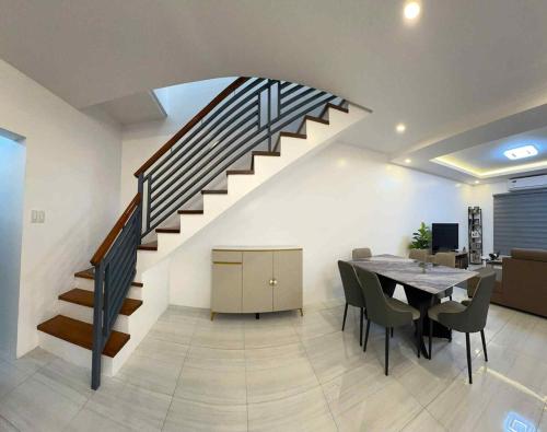 une salle à manger avec une table et un escalier dans l'établissement 4 Bedroom House for 5-6 guests, à Manille