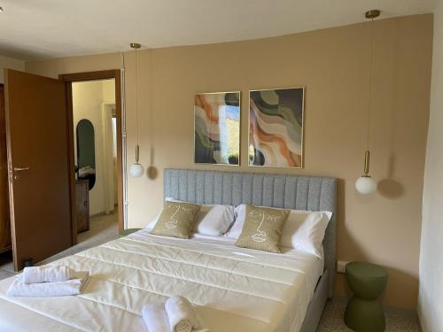 a bedroom with a bed with white sheets and pillows at Casa Piazzetta - Lake Como WiFi & A-C in Dorio
