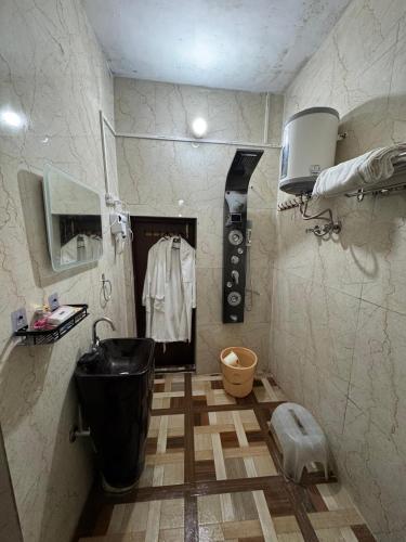 a bathroom with a black tub and a sink at Ufo Mussoorie in Mussoorie