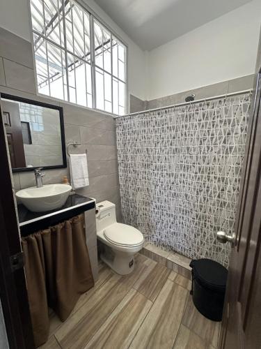 ein Badezimmer mit Toilette, Waschbecken und Spiegel in der Unterkunft Apartamento C Fuertevali in San Salvador