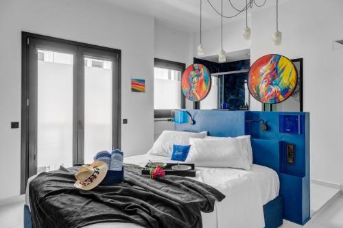 une chambre avec un lit bleu et blanc et des tongs dessus dans l'établissement Artrock Experience Loft Gallery, à Ermoúpoli