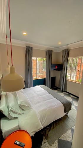 a bedroom with a large bed in a room with windows at Bendito Hostels in Bogotá