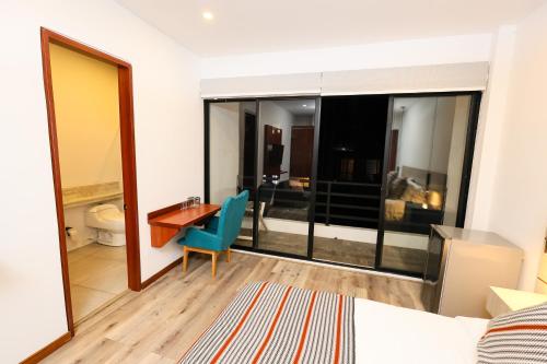 a hotel room with a desk and a bedroom at Hotel Casa PARDO Boutique in Bogotá