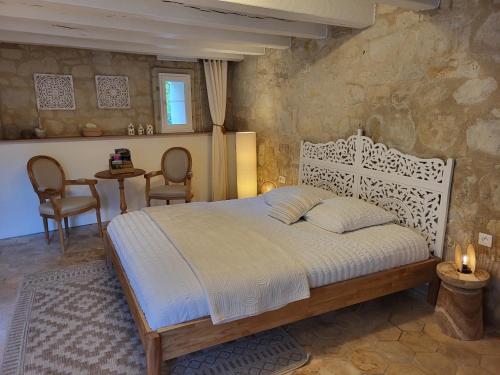 a bedroom with a bed and a table and chairs at La Cale de la Clauderie in Rigny-Ussé
