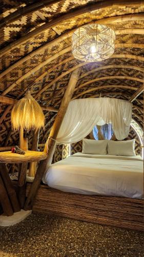 a bedroom with a bed and a chandelier at manta family sidemen in Selat