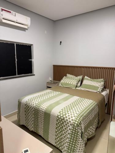 a bedroom with two beds with green and white sheets at Casa no Jardim Abrel in Santa Inês