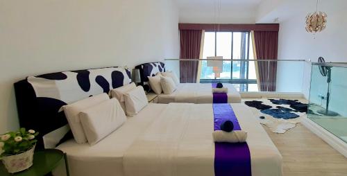 ein Wohnzimmer mit zwei Betten und einer Couch in der Unterkunft Panoramic KLCC Lake view, M CITY Jalan Ampang in Kuala Lumpur