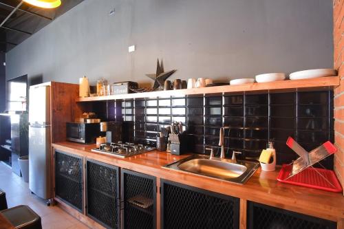 La cuisine est équipée d'un comptoir avec évier et d'un réfrigérateur. dans l'établissement NEW Industrial Loft at Ensenada, à Colonia Cañón Doña Petra