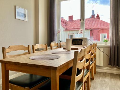 a dining room table and chairs with a window at Grand Hotell & Hostel Strömsund in Strömsund