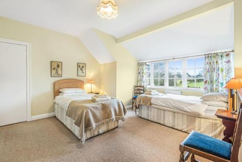 ein Schlafzimmer mit zwei Betten und einem Fenster in der Unterkunft Little Barwick in Stanhoe
