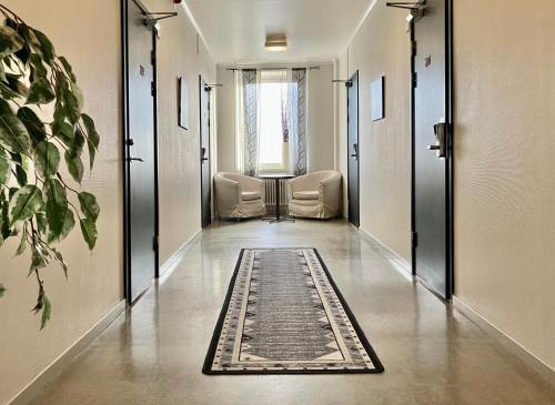 a hallway with two chairs and a rug on the floor at Grand Hotell & Hostel Strömsund in Strömsund