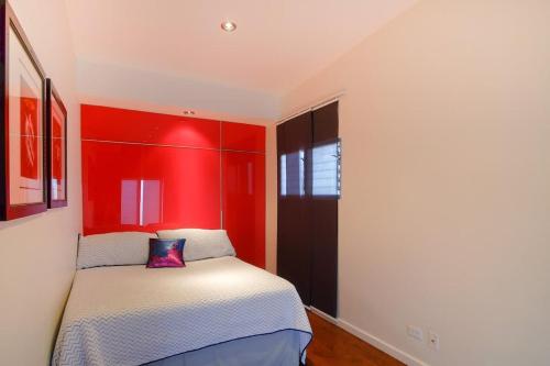 ein Schlafzimmer mit einem Bett mit rotem Kopfteil in der Unterkunft Lovely and Cozy Apartment in Colonia Cañón Doña Petra