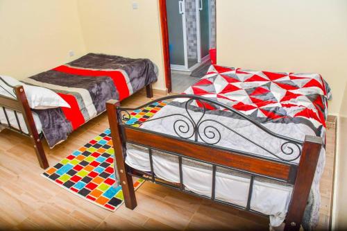 Cette chambre dispose de 2 lits et d'un tapis. dans l'établissement Garden lodge near Ngong with forest walks - 2340, à Kiserian
