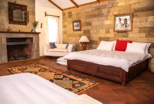 a living room with two beds and a fireplace at Laikipia farmstay Chui Cottage near Nanyuki - 2330 in Timau
