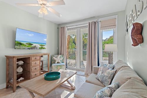 Una sala de estar con un sofá y un televisor en Pilot House 412, en Destin