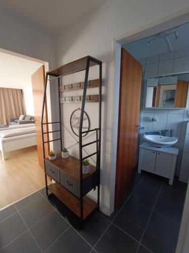 a room with a bathroom with a sink and a mirror at Studio Apartment Staufenflair in Oberstaufen