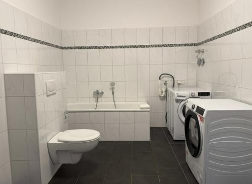 ein Badezimmer mit Toilette und Waschmaschine in der Unterkunft T&K Apartments - Comfortable 4 and 5 room Apartments - 20min Fair Messe CGN in Overath