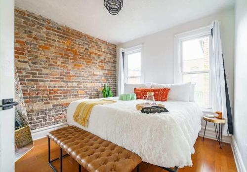 a bedroom with a bed and a brick wall at Jungle House Luxury Homes - Columbus Downtown Short North - Steps to Convention Center & Nationwide Arena - Sleeps up to 8 - Free Parking - Over 5,800 Five Stars in Columbus