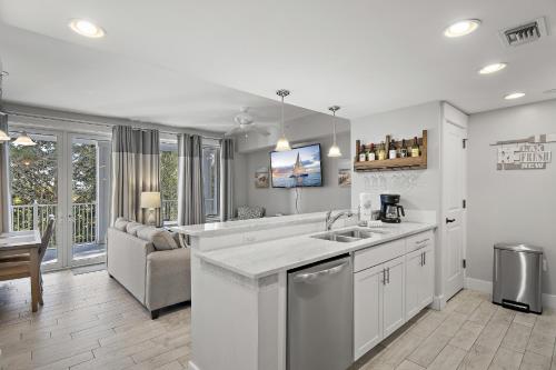 a kitchen with a sink and a living room at Pilot House 413 in Destin