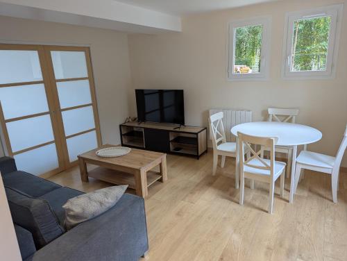 a living room with a couch and a table and a tv at Cozy apartment with terrace in Crach