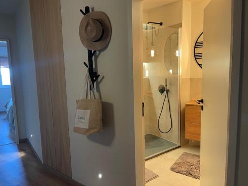a bathroom with a shower with a hat on the wall at BestHomeStay-Santiago do Cacém in Santiago do Cacém