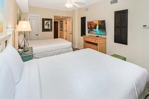 a hotel room with two beds and a tv at Pilot House 507 in Destin