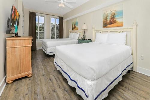 a bedroom with two beds and a television in it at Pilot House 507 in Destin