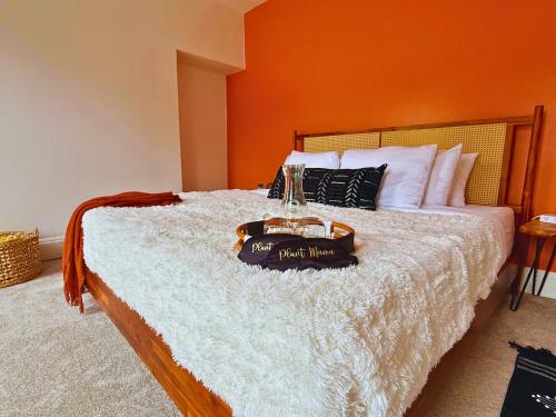 a bedroom with a bed with an orange wall at Jungle House Luxury Stays - Columbus Downtown Short North in Columbus