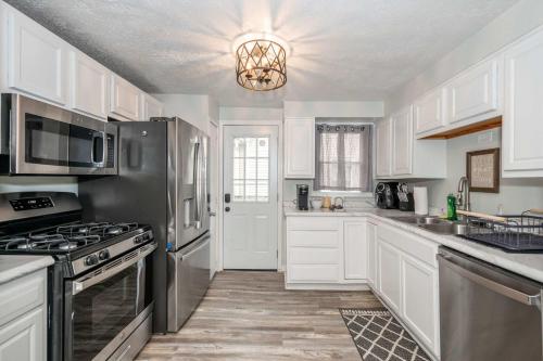 una cucina con armadietti bianchi ed elettrodomestici in acciaio inossidabile di The Washington Cottage - 6ppl a Harrison