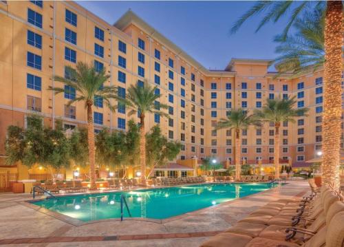 a hotel with a swimming pool in front of a building at Wyndham Grand Desert - 1 BR-Apartment with Resort Access in Las Vegas