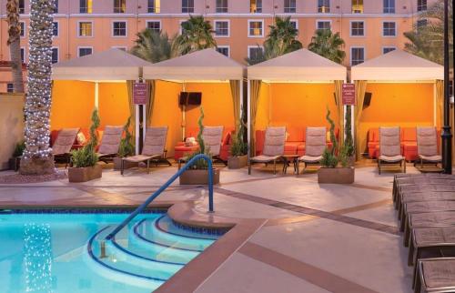 a pool at a hotel with chairs and umbrellas at Wyndham Grand Desert - 1 BR-Apartment with Resort Access in Las Vegas