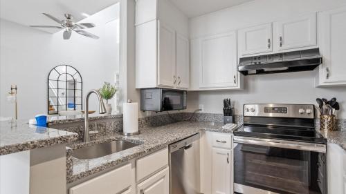 a kitchen with white cabinets and a sink at Downtown Condo - 2BR 2BA Walk to Everything in Raleigh