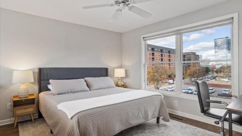 a bedroom with a bed and a large window at Downtown Condo - 2BR 2BA Walk to Everything in Raleigh