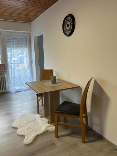 a dining room with a table and a clock on the wall at MelsHome Entire apartment to feel good in Geislingen an der Steige