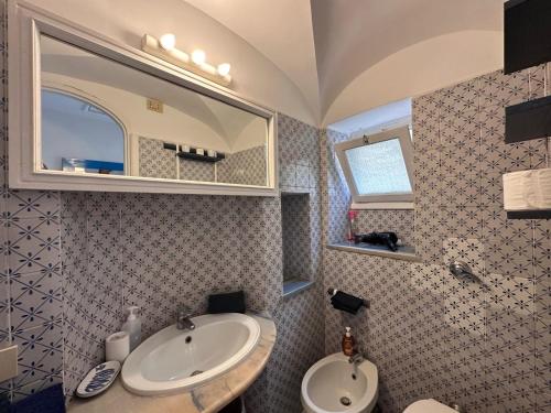 a bathroom with a sink and a mirror at Center Apartment Capri in Capri