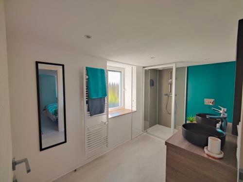 een badkamer met een zwarte wastafel en een spiegel bij Gîte Noël - Jacuzzi, Sauna et Calme absolu in La Celle-sous-Gouzon