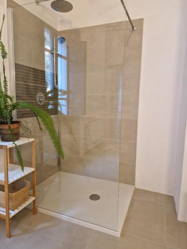 a shower with a glass door in a bathroom at Casa S'Urtzula in Sini